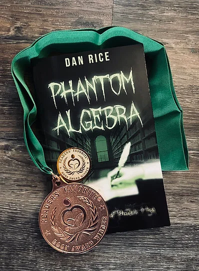 Book cover of Dan Rice’s Phantom Algebra on a wooden table with a green ribbon and two Readers’ Favorite award medals.