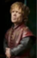 Serious man in a burgundy embroidered leather tunic stands against a dark background